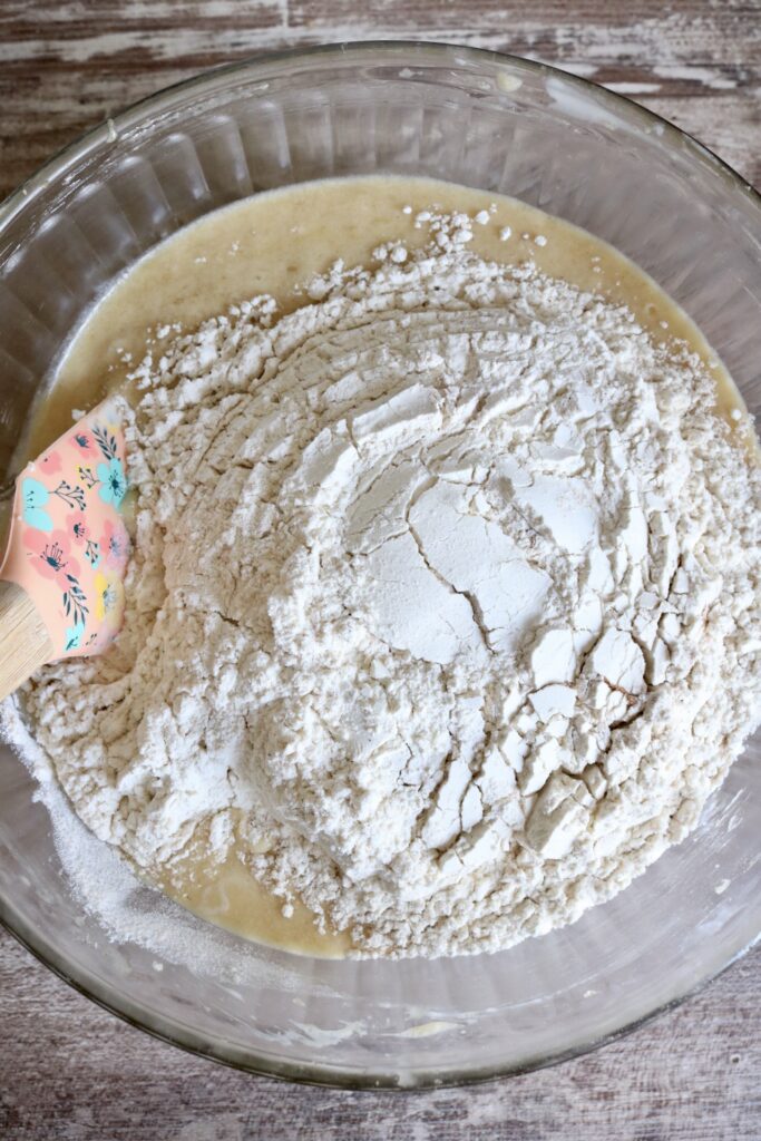 dry ingredients added to wet ingredients in a glass bowl