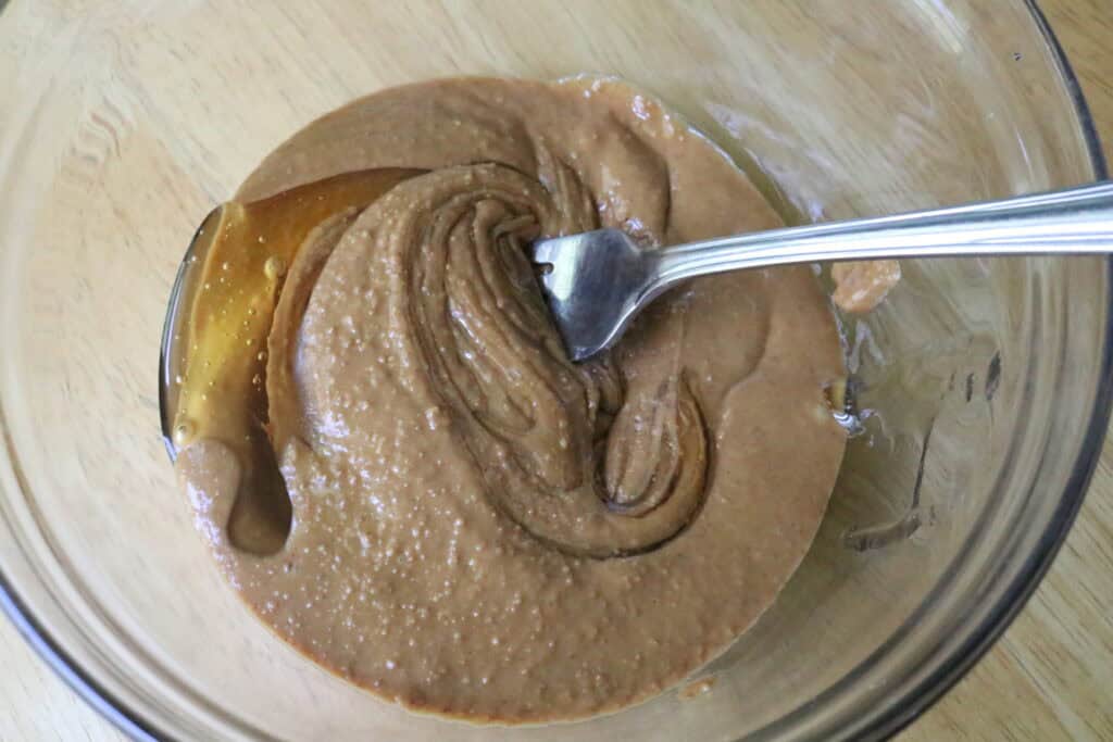 peanut butter and honey in a glass bowl with a fork