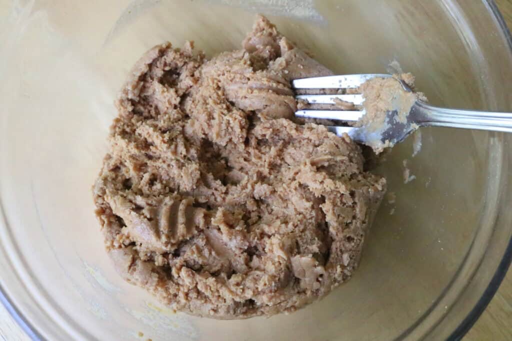 peanut butter dough being stirred with a fork