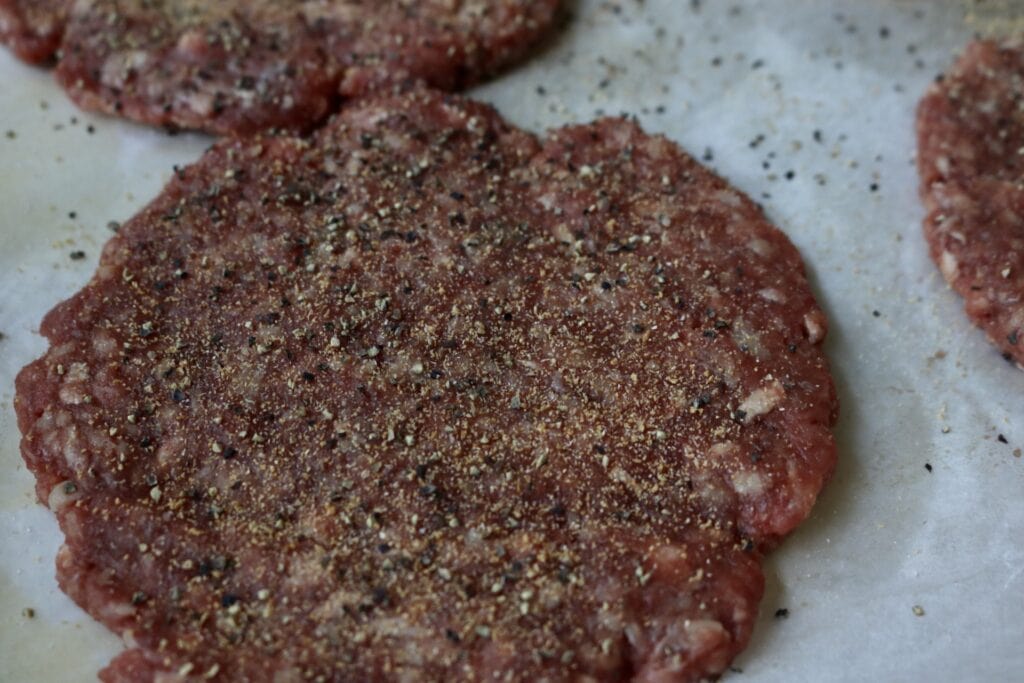 close up of a burger patty with seasonings on it