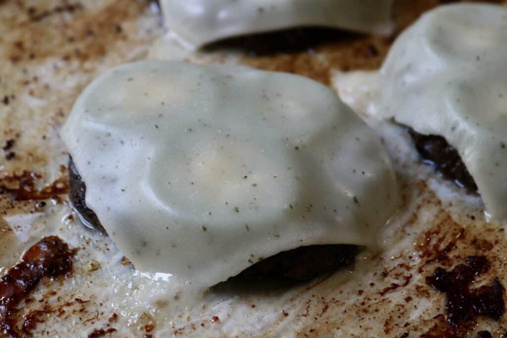 close up of a burger patty with cheese melted on it