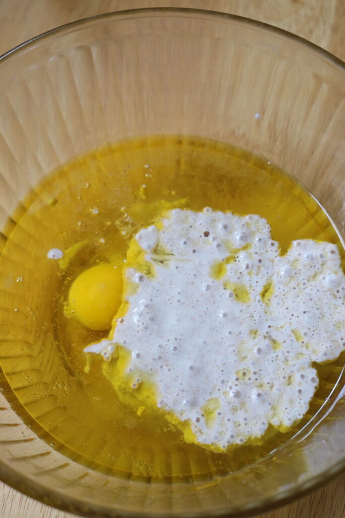 eggs, oil, water, and sourdough starter in a glass bowl