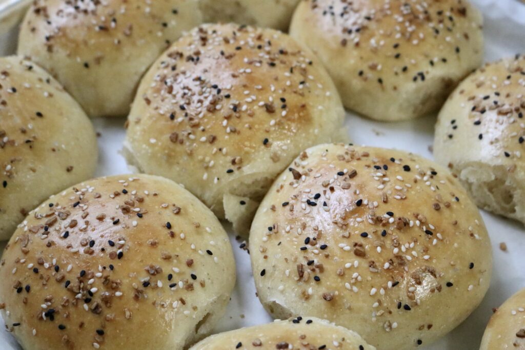 sourdough burger buns on a baking sheet