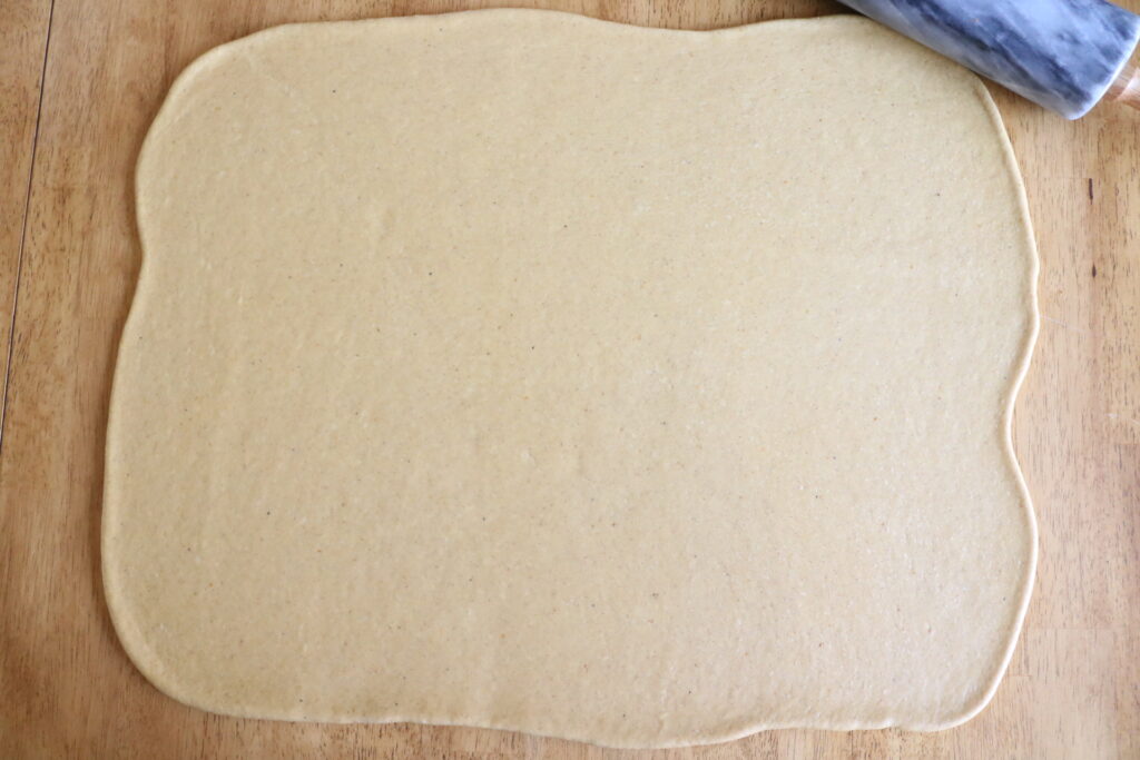 dough rolled out in a rectangle on wood countertop