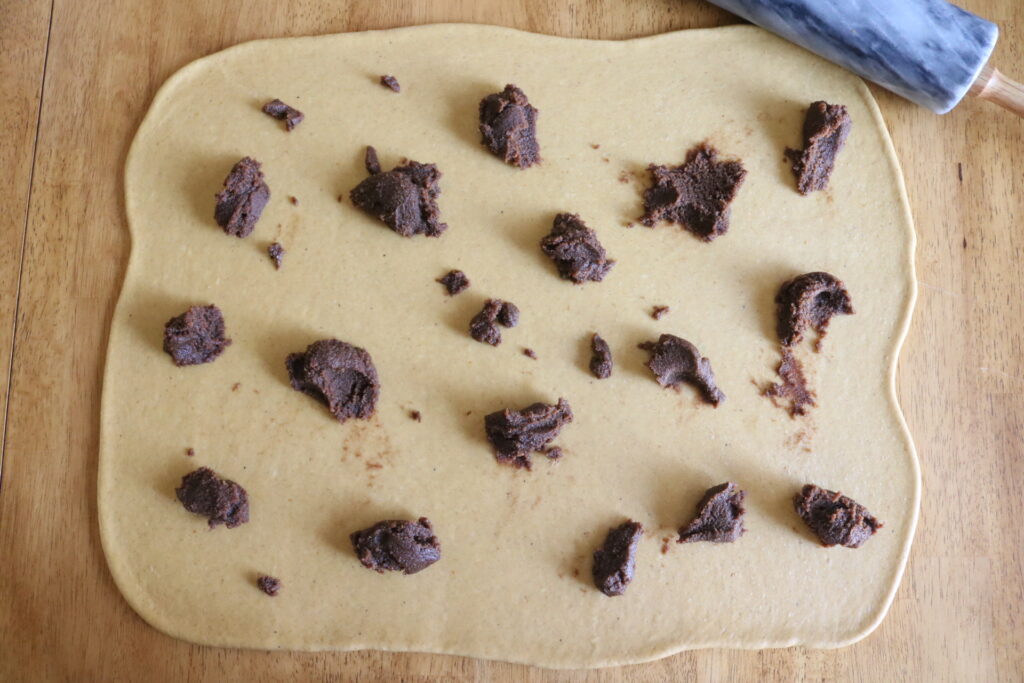 cinnamon roll filling spooned out on rectangle of dough