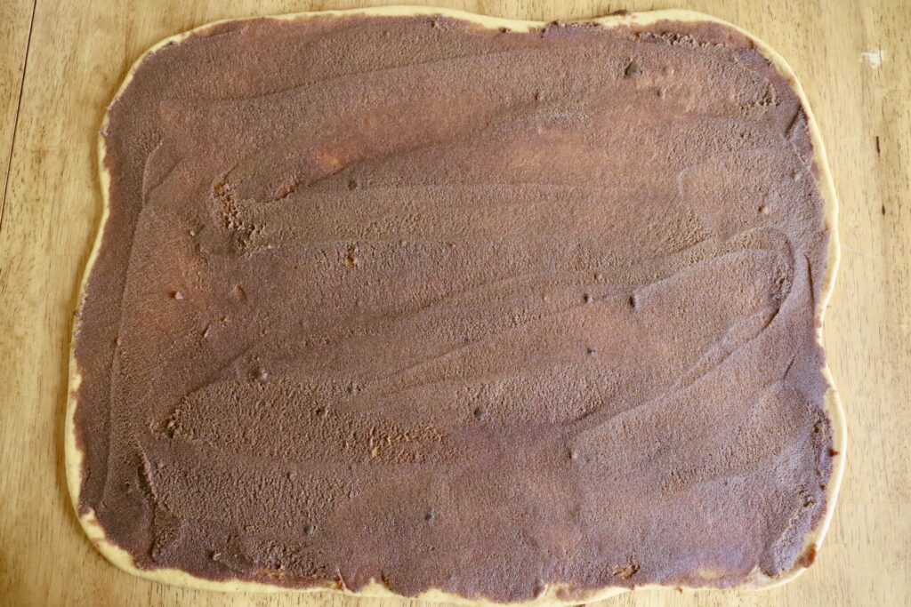 cinnamon roll filling spread out evenly all over dough