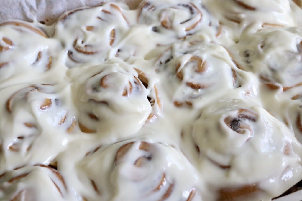 pan of frosted sourdough pumpkin cinnamon rolls