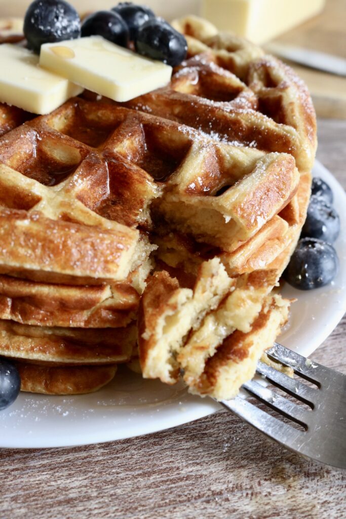a fork cut into a stack of four protein waffles