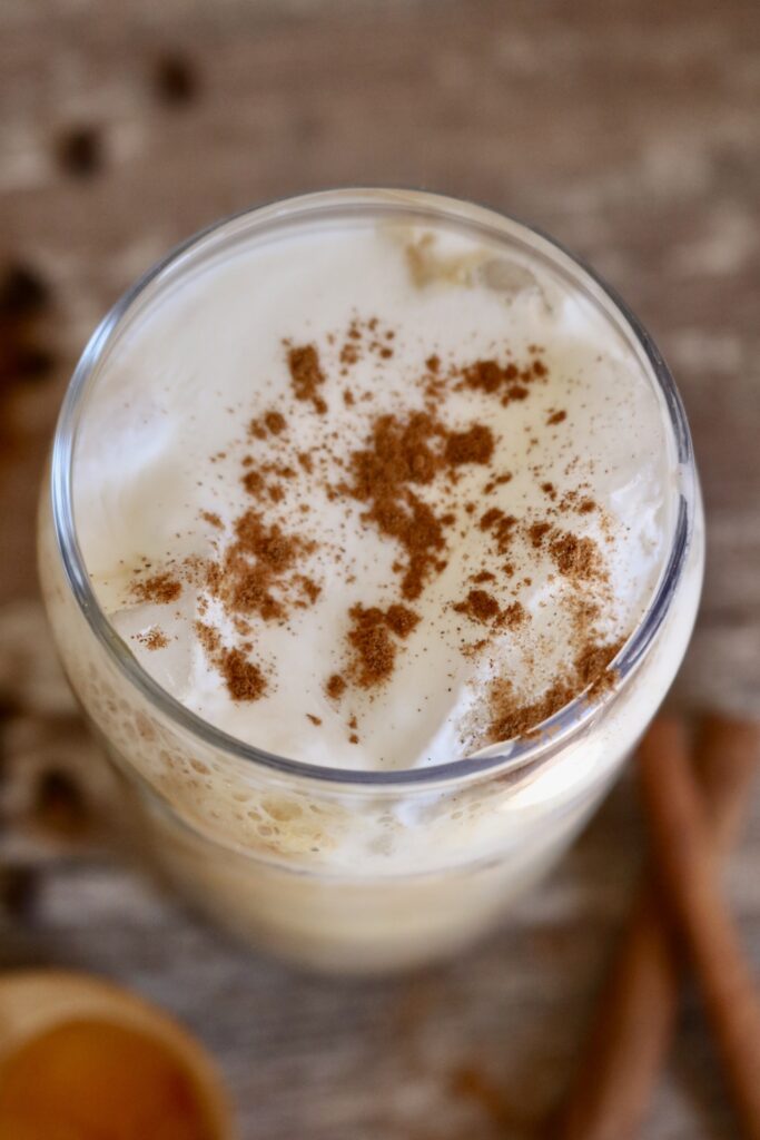 top view of an iced cinnamon honey latte with cold foam and cinnamon sprinkles on top