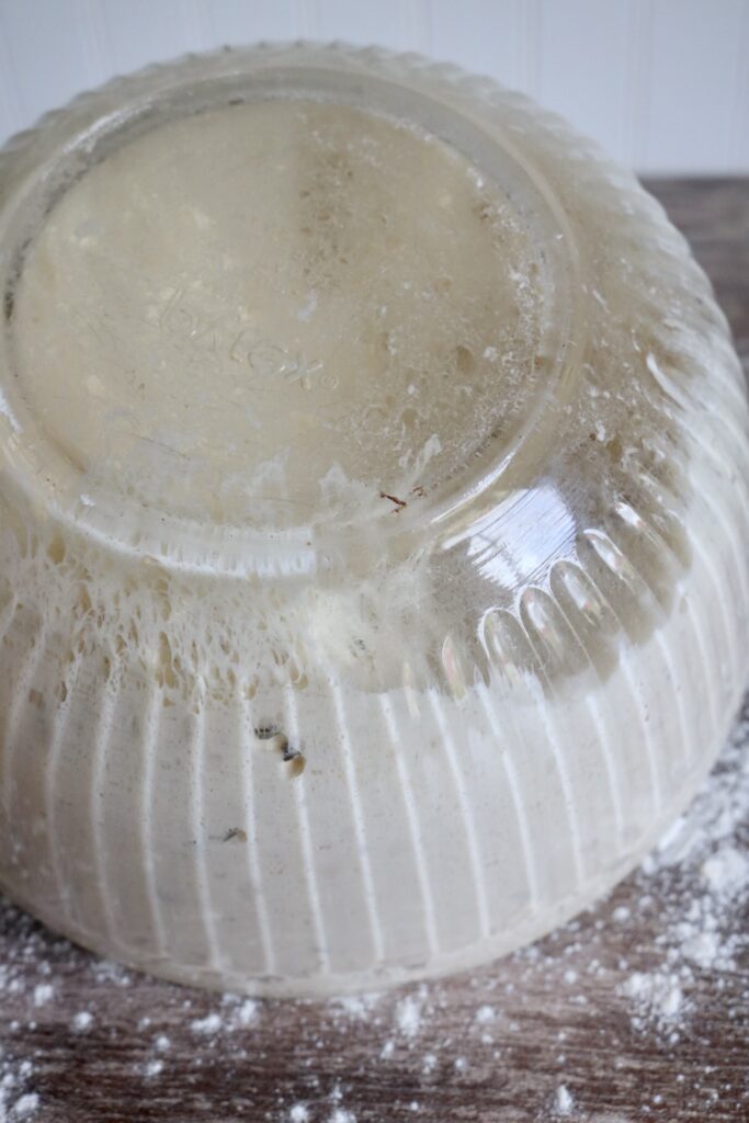 pouring dough out of a glass bowl