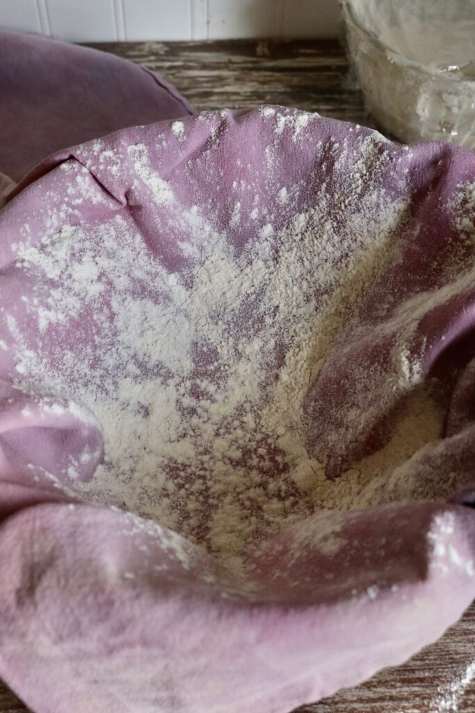bowl lined with a tea towel sprinkled with flour