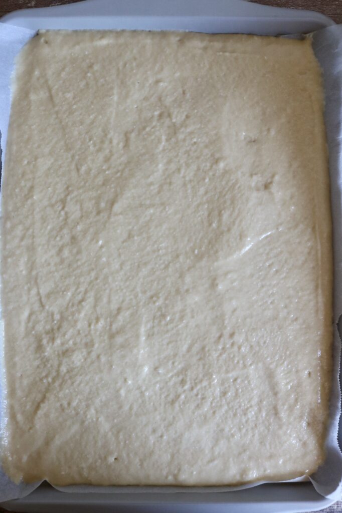 cake batter spread out on a sheet pan