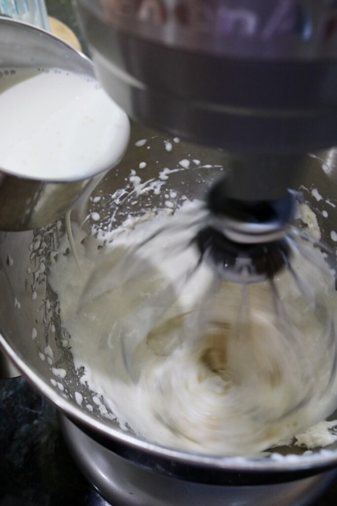 stand mixer running while pouring in heavy cream