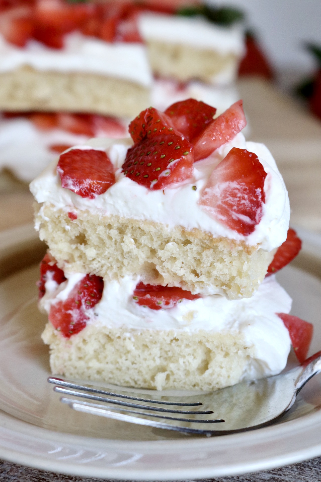 piece of sourdough discard strawberry shortcake on a plate with a fork