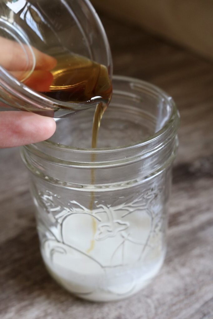 pouring maple syrup into milk