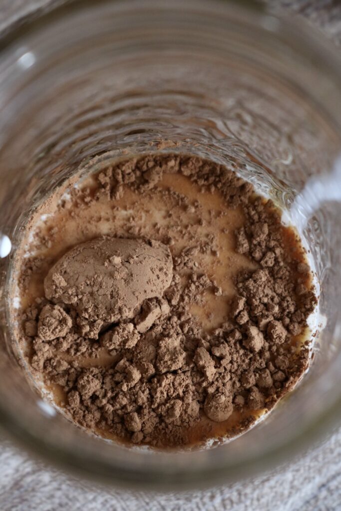 cocoa powder on top of milk in a jar