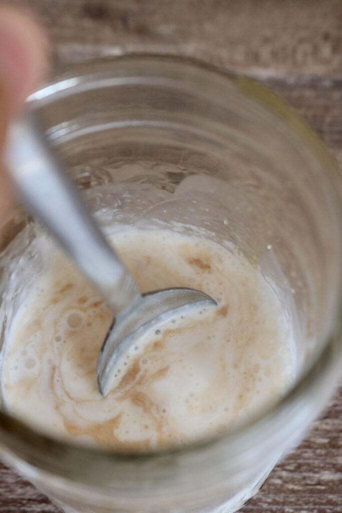 stirring orange cold foam ingredients together with a spoon