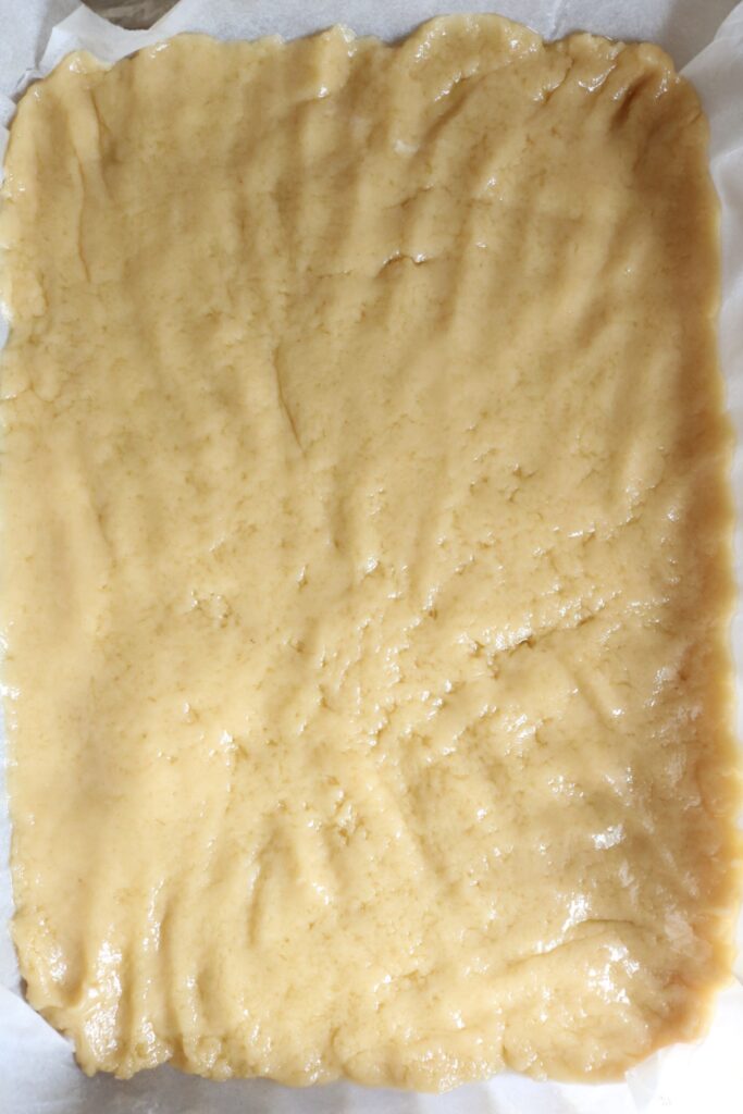 shortbread crust pressed into a parchment paper lined pan