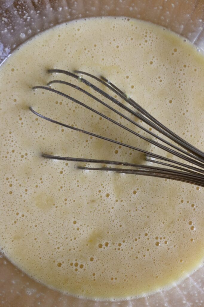 lemon custard filling in a bowl with a whisk