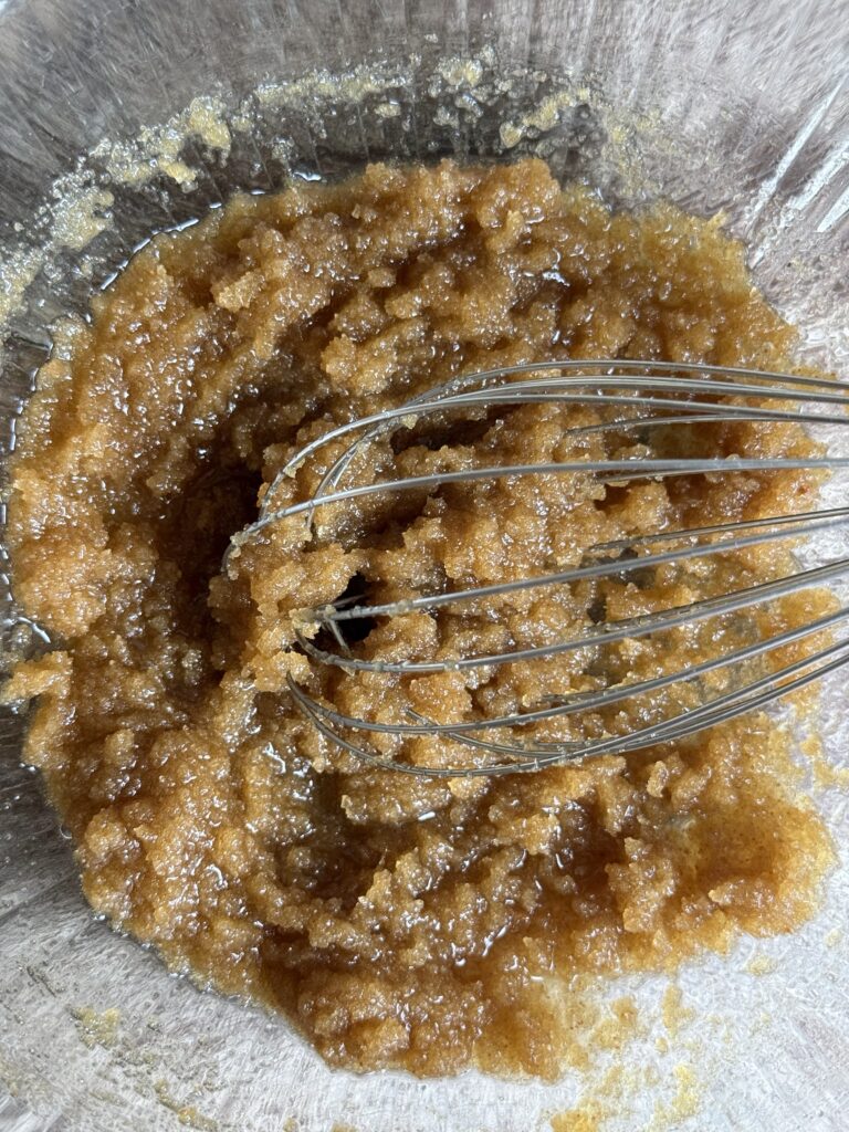 whisking sugar and melted butter in a bowl