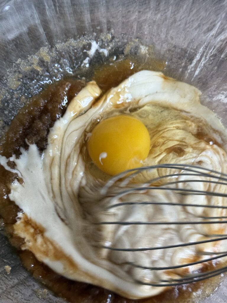 whisking egg and sourdough starter into sugar mixture