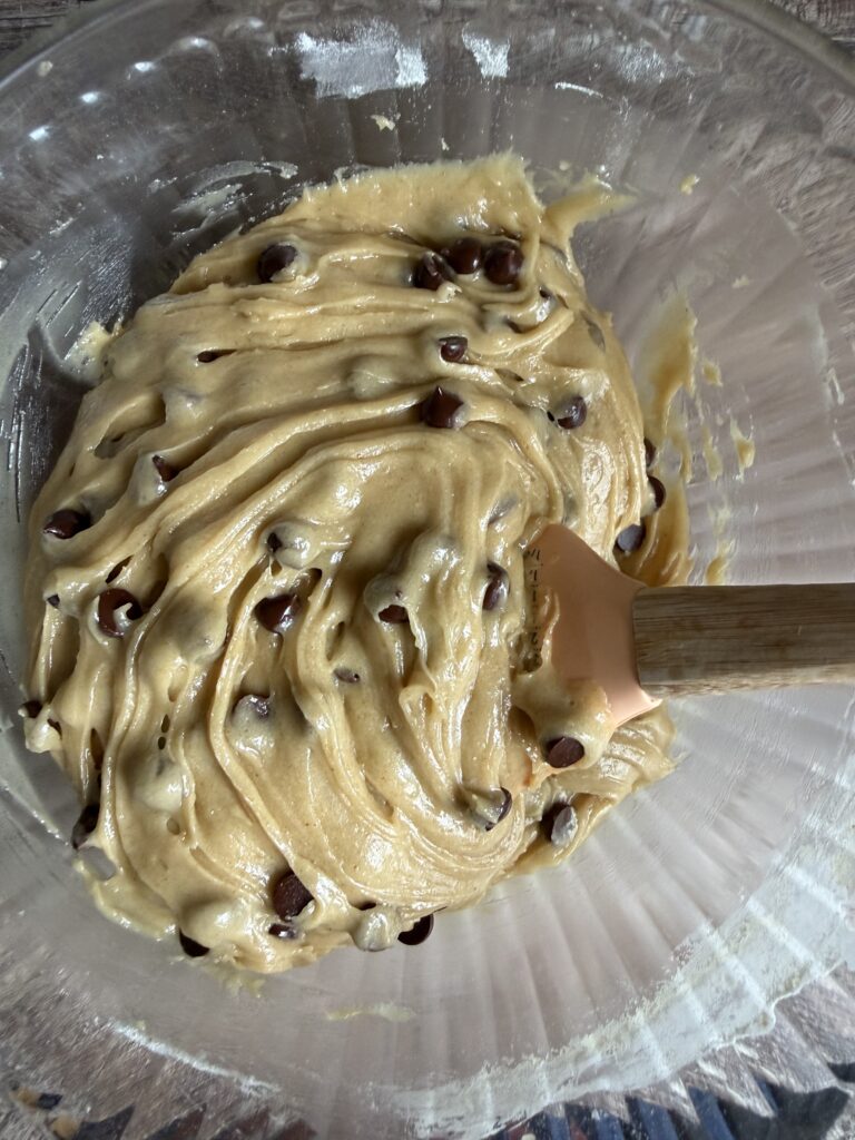 stirring chocolate chip cookie batter with a rubber spatula