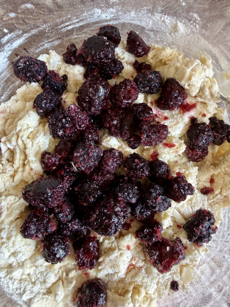 blackberries on top of dough in a bowl