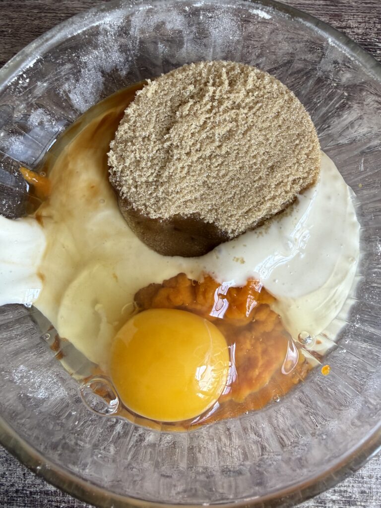 brown sugar, egg, pumpkin puree, and sourodough starter in a bowl