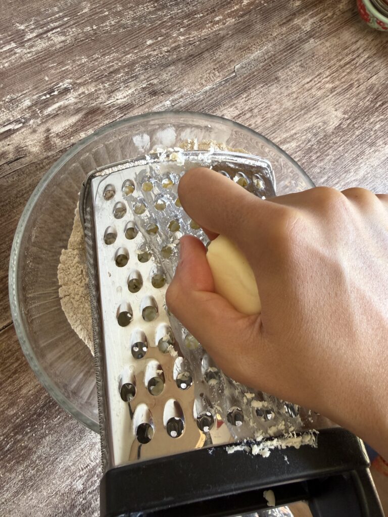 grating butter by hand with a cheese grater