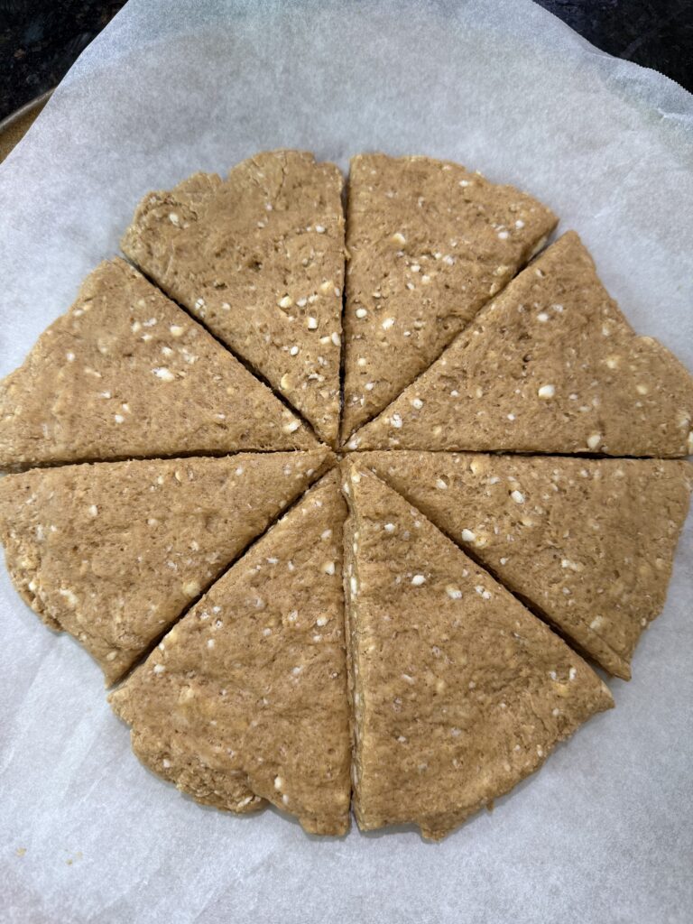 circle of sourdough pumpkin scone dough sliced into 8 triangles