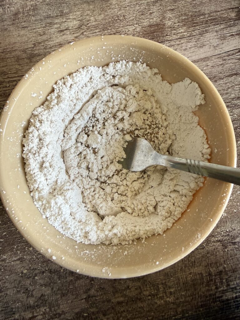 stirring milk into powdered sugar