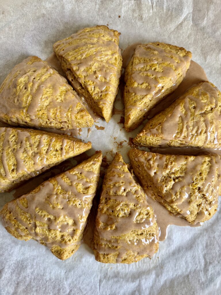circle of glazed sourdough pumpkin scones on parchment paper