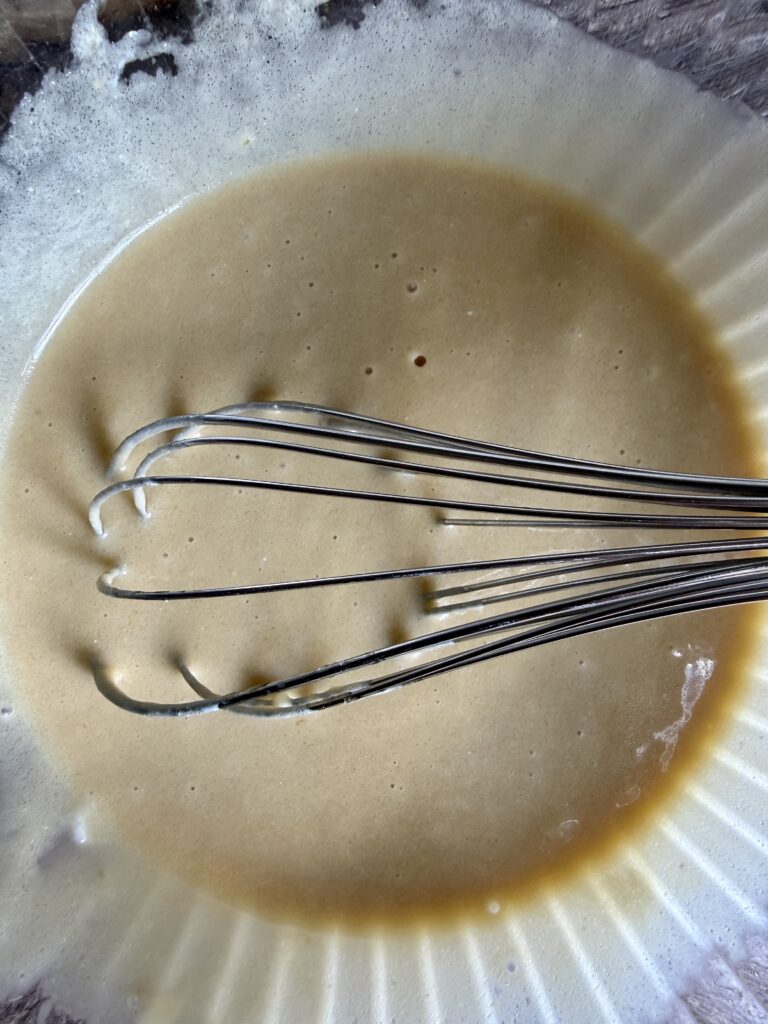 whisking wet ingredients together in a glass bowl