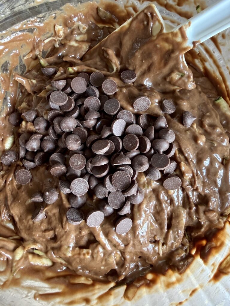 chocolate chips in a bowl of sourdough double chocolate zucchini bread batter