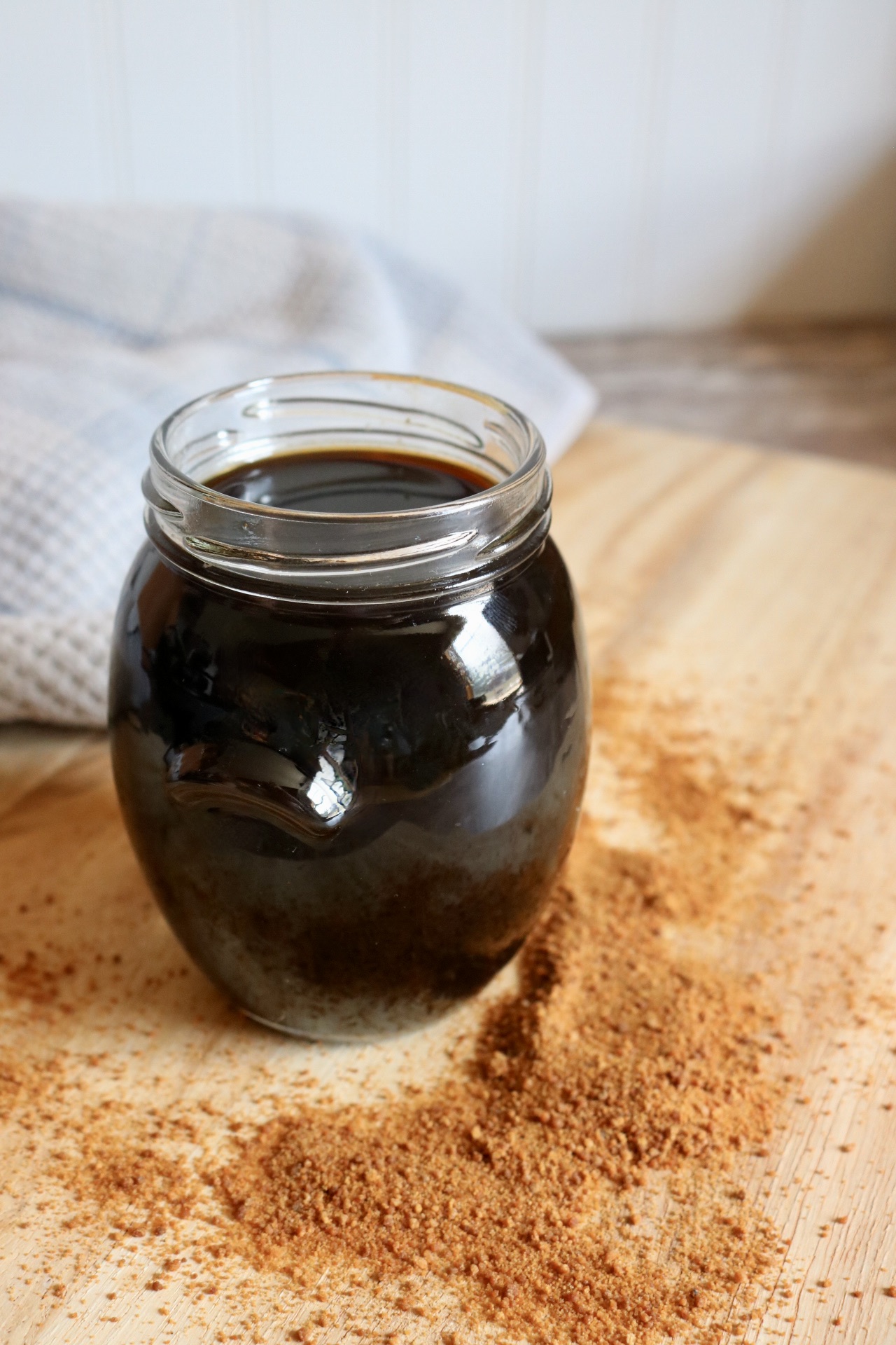jar of coconut sugar coffee syrup on a wood board with coconut sugar on the board
