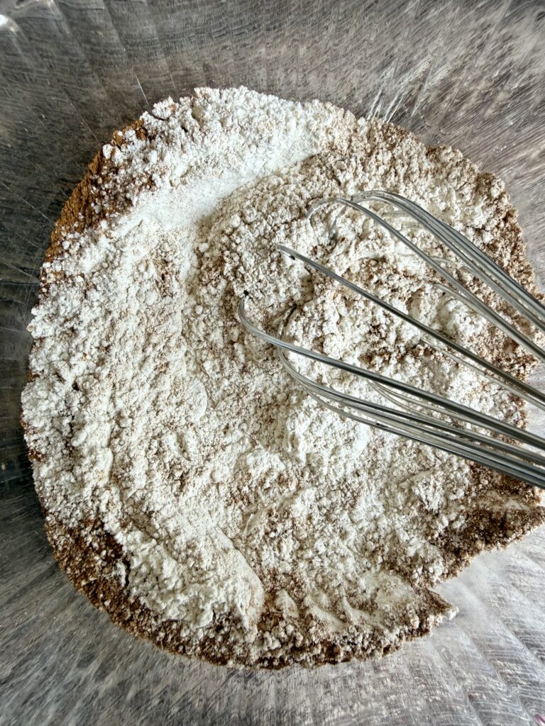 whisking flour and spices together in a glass bowl
