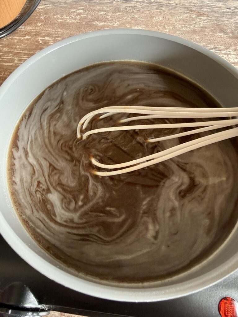 whisking coffee syrup in a pan