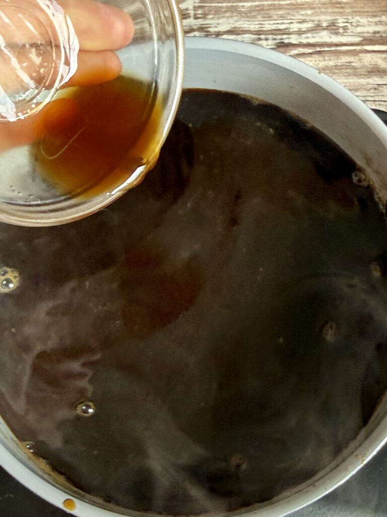pouring vanilla into coffee syrup