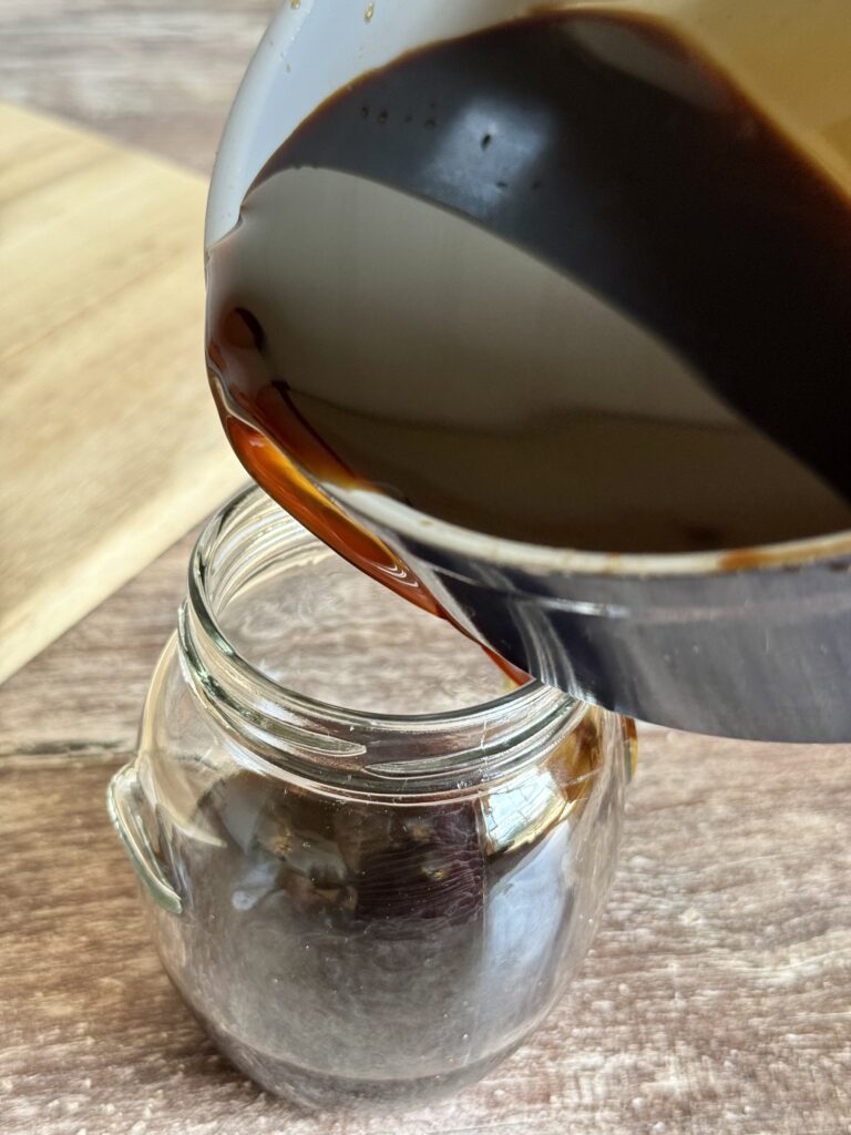 pouring coffee syrup into a jar