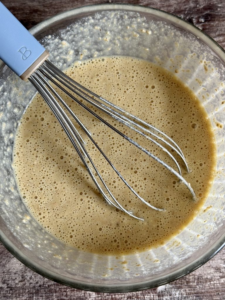 batter in a glass bowl with a whisk
